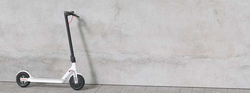 An E-Scooter against a grey wall.